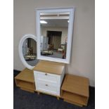 A contemporary two tone bedside chest together with bedside stands and two white framed mirrors