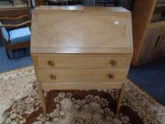 A twentieth century satin wood writing bureau fitted with two drawers on raised legs,