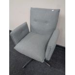 A contemporary swivel desk chair in grey buttoned fabric