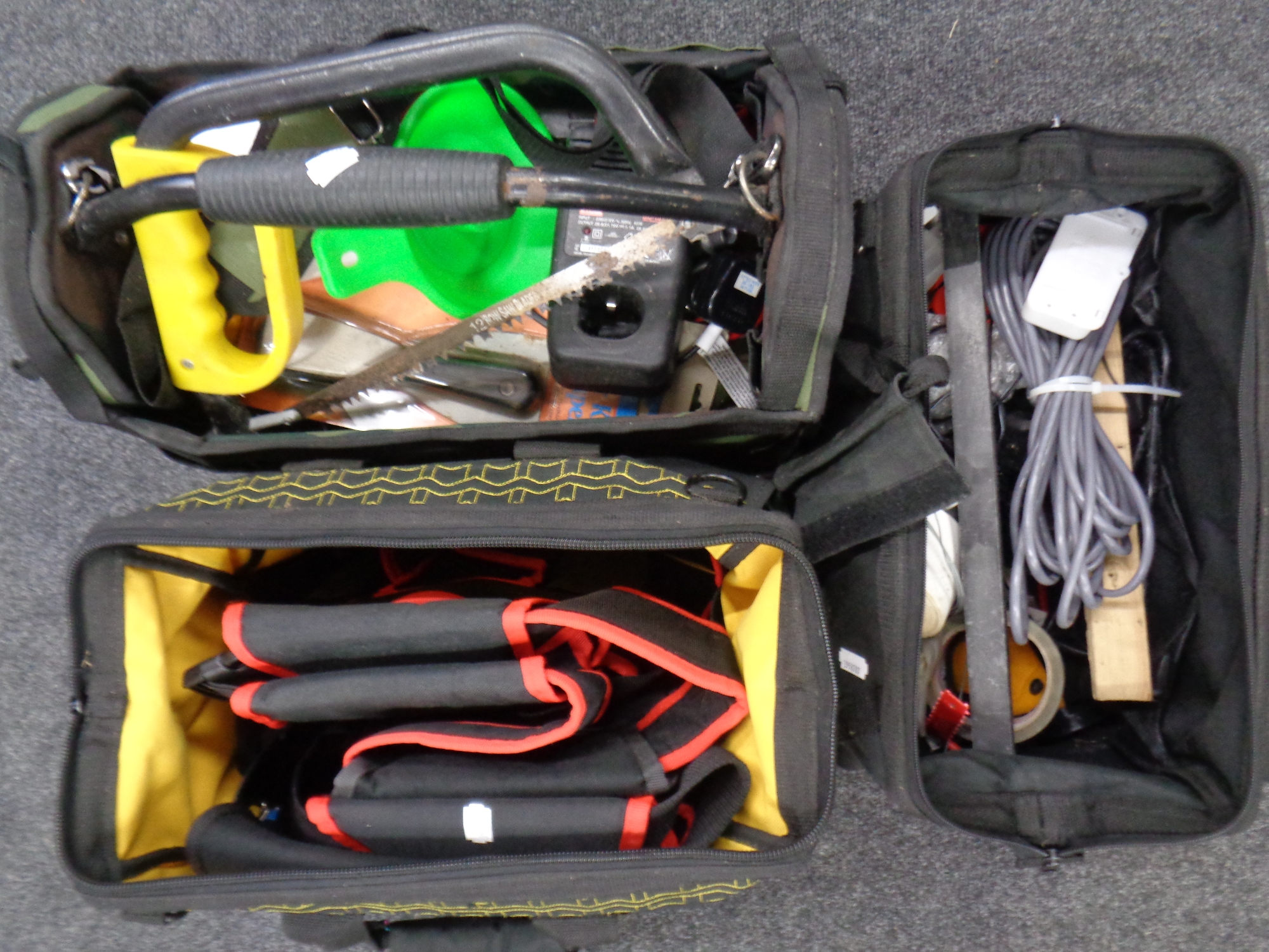Three tool bags containing hand tools, tapes, saws, Ryobi batter charger,