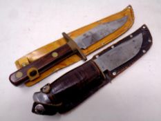 Two hunting knives in leather sheaths