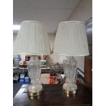 A pair of cut glass table lamps with shades.