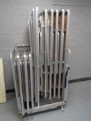 A metal trolley containing ten stainless steel framed banqueting tables