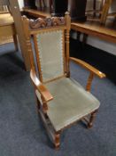 A carved oak armchair upholstered in a dralon fabric