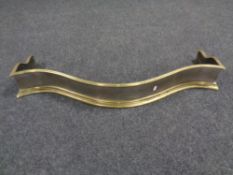 A Victorian brass and cast iron shaped front fire curb
