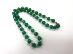 A green hard stone and pearl necklace with gold clasp