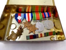 Four WWII medals on ribbons together with a St John's Ambulance medal and a ring