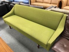 A mid century Danish day bed upholstered in a green fabric