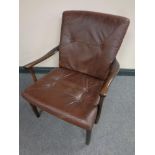 A Scandinavian stained beech framed armchair in brown buttoned leather