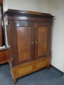 A late 19th century inlaid mahogany double door cabinet on two drawer base