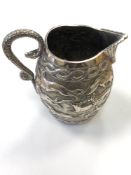 An ornate Indian silver jug embossed with lions,