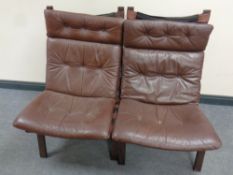 A pair of Danish Farstrup lounger chairs with brown leather cushions
