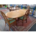 A 20th century oval Nathan teak extending dining table together with five chairs