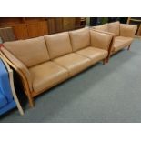 A Danish Skalma beech framed three seater settee and two seater settee in brown leather
