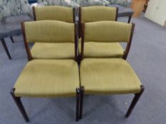 A set of four mid century dining chairs in olive fabric