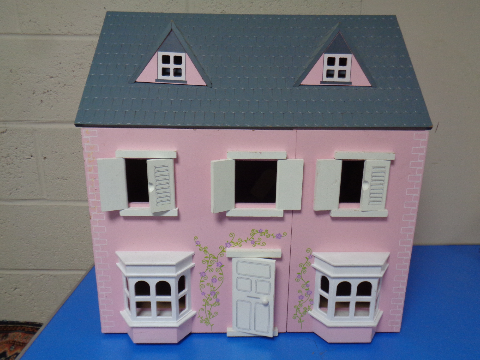 A wooden dolls house with accessories