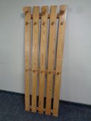 A wall mounted pine slatted hat and coat rack