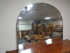 An un-framed domed topped mirror