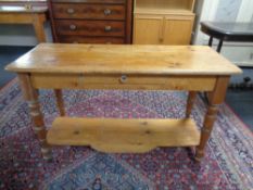 An Edwardian pine two tier side table with glass handle