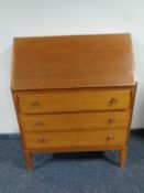 A mid century writing bureau fitted with three drawers