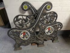 A pair of cast iron ornate bench ends