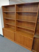 A pair of mid century Danish teak bookshelves fitted with cupboards below