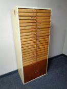 A mid century forty drawer filing chest fitted with cupboards beneath