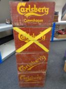 Four vintage brewery crates bearing Carlsberg advertising