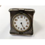 An antique silver cased travel clock