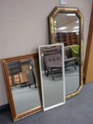 A contemporary octagonal framed mirror together with two further framed mirrors