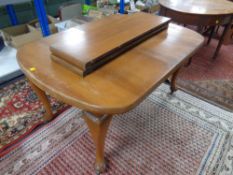 An Edwardian mahogany extending dining table with two leaves on Queen Anne style legs