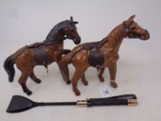 Two brown stitched leather horse figures, together with a small whip.