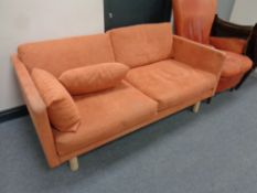 A Scandinavian two seater settee in peach fabric