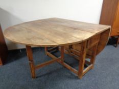 A 19th century pine drop leaf kitchen table fitted a drawer