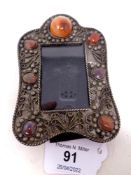 An ornate miniature white metal picture frame with polished stone decoration, height 12 cm,