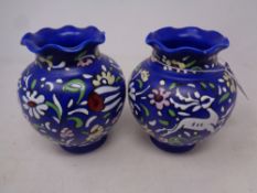 A pair of Neofito art pottery vases on blue ground and raised painted decoration, height 14 cm.