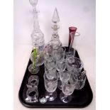 A tray of glass, decanters with ceramics labels, etched drinking glasses, vases,