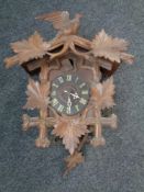 A Black Forest style carved cuckoo clock with weights