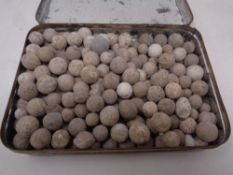 A vintage tin containing excavated musket balls and shot