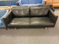 A Danish black leather two seater settee on raised chrome legs