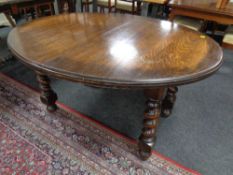 An Edwardian oak oval dining table on barleytwist legs