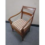 A 19th century mahogany armchair with striped cushion