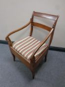 A 19th century mahogany armchair with striped cushion