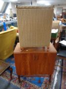 A mid century teak double door record cabinet together with a Lloyd Loom glass topped linen box