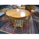 A circular pine table together with four chairs