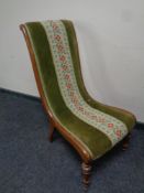 An early 20th century mahogany nursing chair upholstered in tapestry dralon