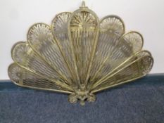 A brass peacock fan fire screen