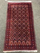 An Afghan rug, with lattice design on red ground,