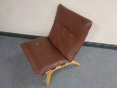 A 20th century Danish low backed lounger chair with brown buttoned leather cushion
