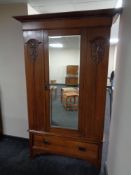 An Edwardian oak Art Nouveau mirror door wardrobe fitted a drawer